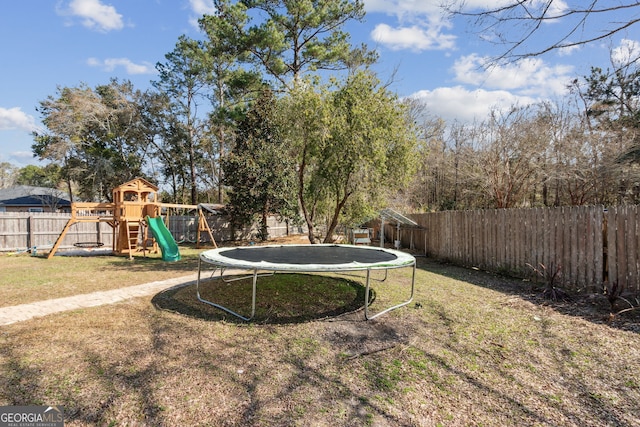 view of yard with a trampoline and a playground