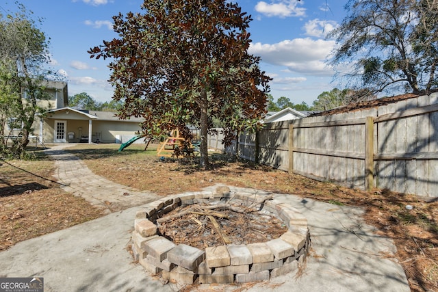 view of yard with a playground, a patio, and a fire pit