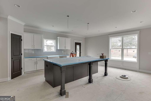 kitchen with tasteful backsplash, white cabinets, and ornamental molding