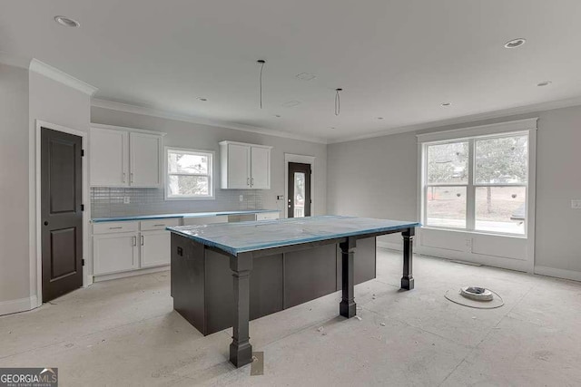 kitchen featuring backsplash, white cabinetry, crown molding, and baseboards