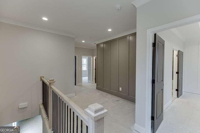 hall featuring recessed lighting, an upstairs landing, ornamental molding, and a decorative wall