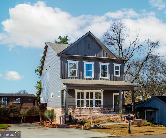 view of front of property featuring brick siding, covered porch, and board and batten siding