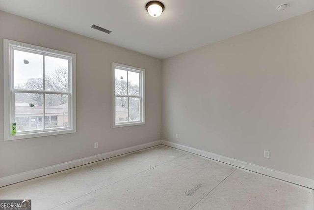 empty room with visible vents, concrete floors, and baseboards