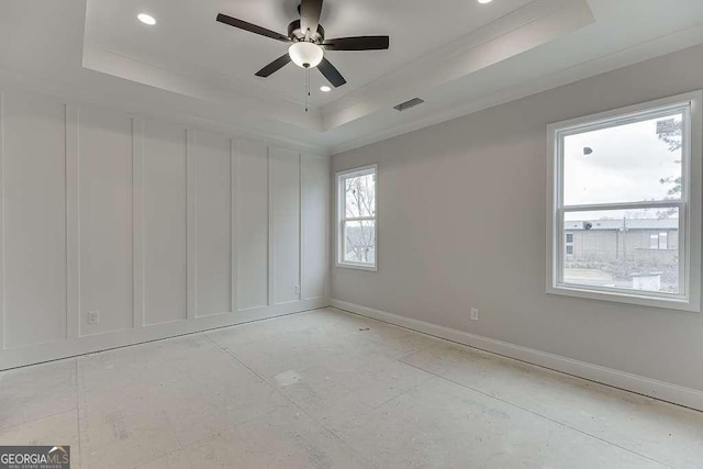 spare room with recessed lighting, a tray ceiling, baseboards, and visible vents