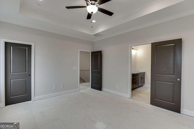 unfurnished bedroom featuring a tray ceiling, recessed lighting, baseboards, and ensuite bathroom