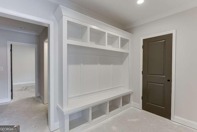 mudroom featuring crown molding, concrete floors, and baseboards