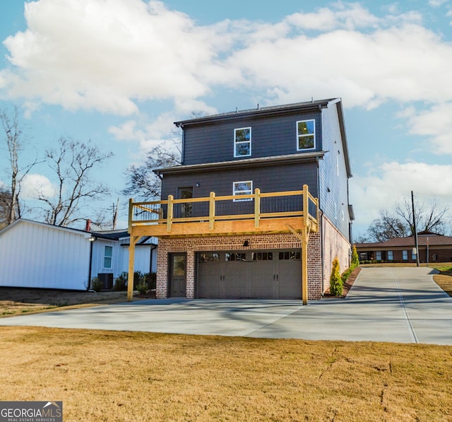 view of front of house with brick siding, a garage, concrete driveway, and a front yard