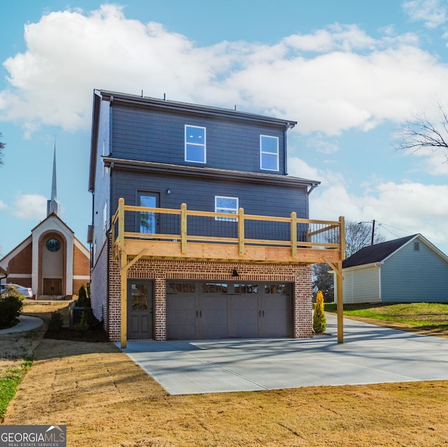 view of front of home featuring a garage, brick siding, concrete driveway, and a front yard