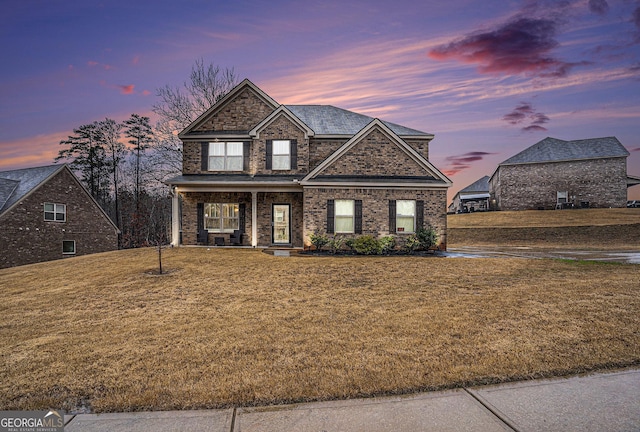 view of front facade with a yard and covered porch