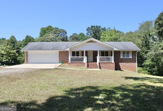 ranch-style house with a garage, a porch, and a front yard