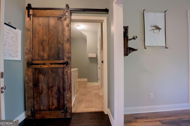 bathroom featuring a barn door and dark hardwood / wood-style floors