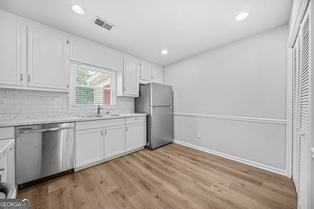 kitchen with sink, light hardwood / wood-style flooring, stainless steel appliances, and white cabinets