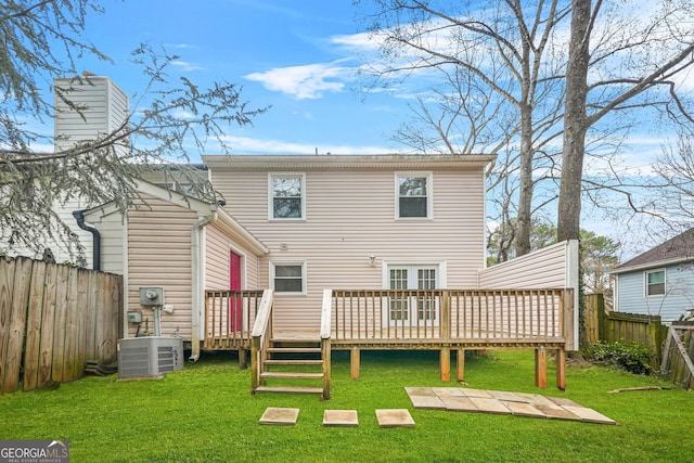 back of house featuring central AC, a deck, and a lawn