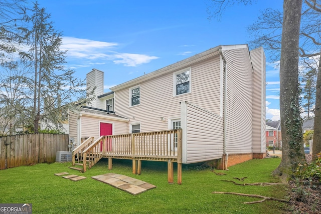 rear view of property featuring a deck, a lawn, and central air condition unit