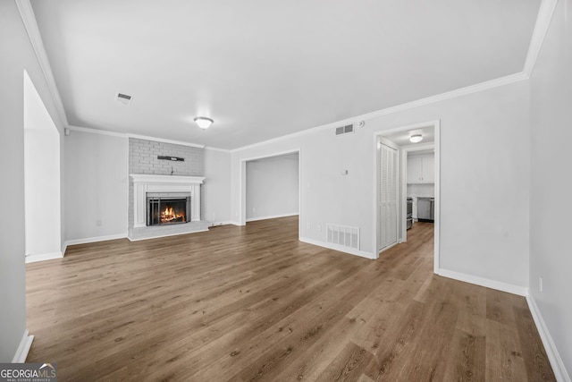 unfurnished living room featuring crown molding, hardwood / wood-style floors, and a fireplace