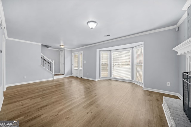 unfurnished living room with hardwood / wood-style floors, a fireplace, and ornamental molding