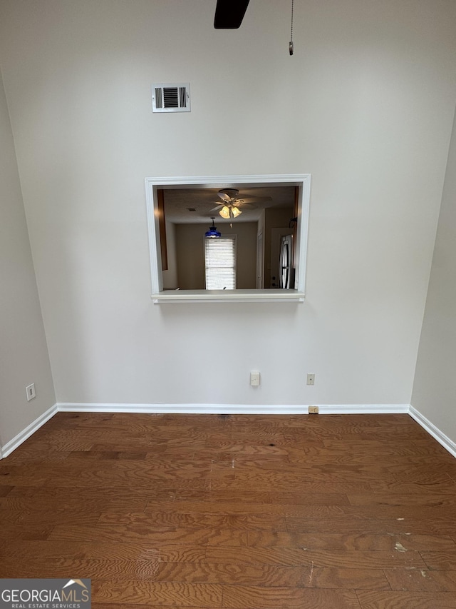 unfurnished room with dark wood-type flooring and ceiling fan