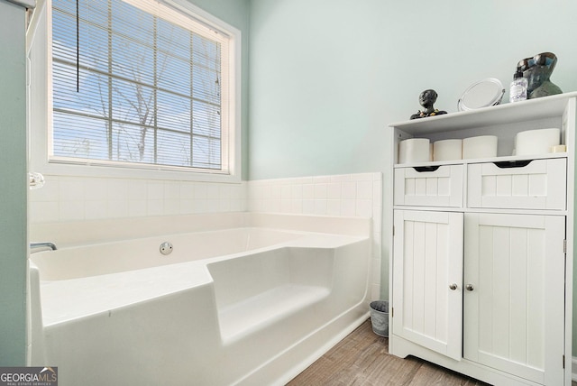 bathroom featuring a garden tub and wood finished floors