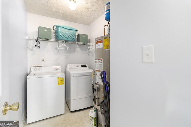 washroom featuring laundry area, washing machine and clothes dryer, a textured ceiling, light floors, and gas water heater