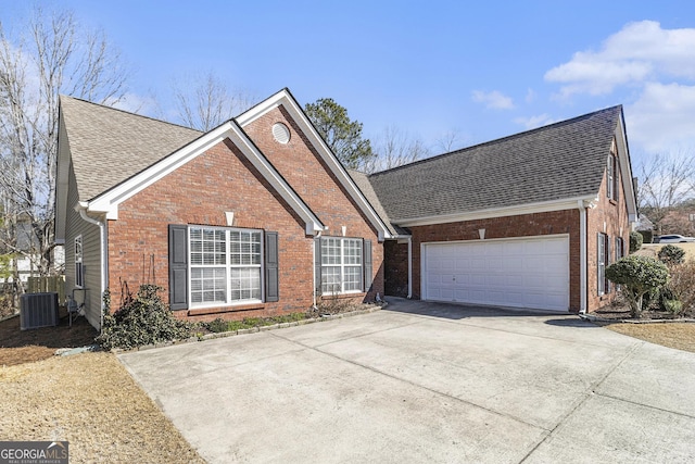 view of front of property featuring a garage, central AC, concrete driveway, and brick siding