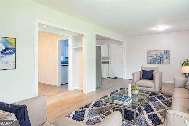 living room with baseboards and light wood-style floors