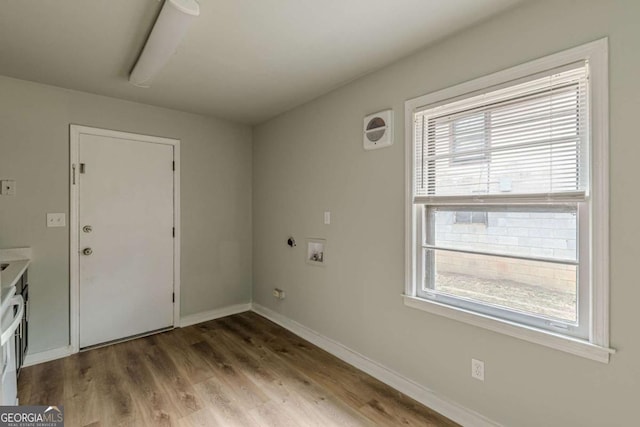 laundry room featuring washer hookup, a wealth of natural light, cabinets, and light wood-type flooring