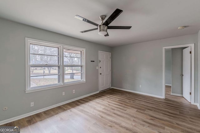 spare room with ceiling fan and light wood-type flooring