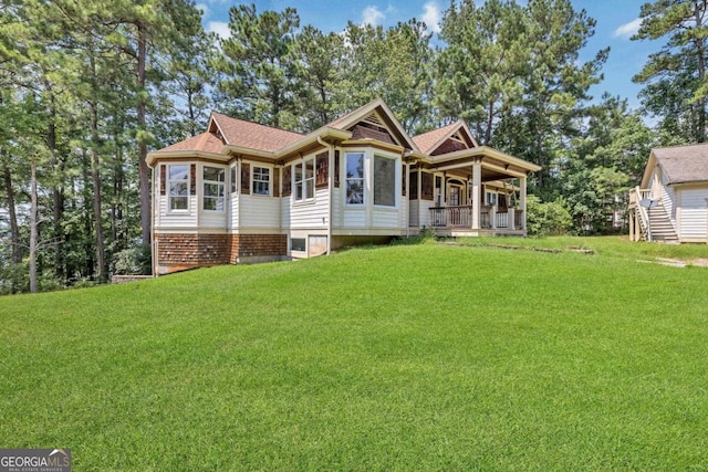 view of front of home with covered porch and a front lawn