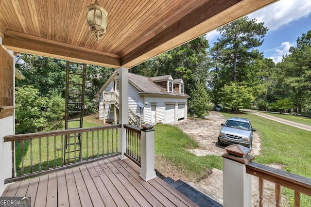 deck featuring an outbuilding, a yard, and a garage