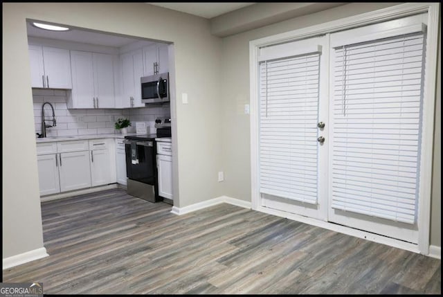 kitchen featuring sink, dark wood-type flooring, stainless steel appliances, and white cabinets