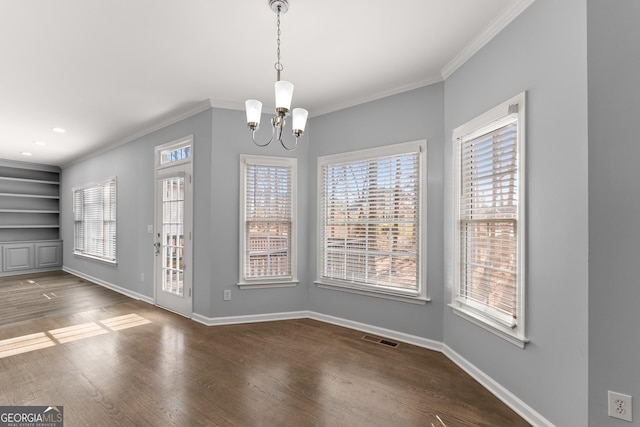 unfurnished dining area featuring ornamental molding, visible vents, baseboards, and wood finished floors