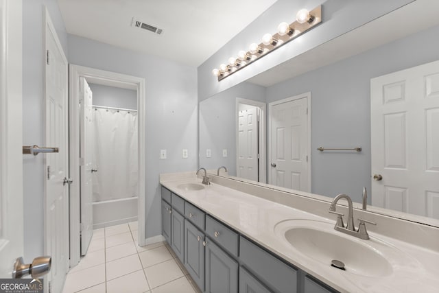 bathroom with double vanity, a sink, visible vents, and tile patterned floors