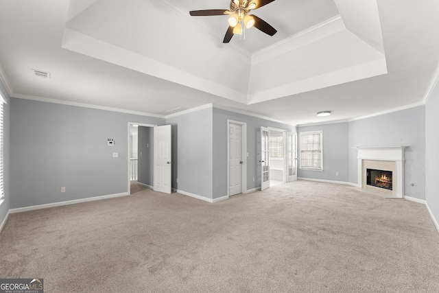 unfurnished living room featuring ornamental molding, a tray ceiling, and visible vents