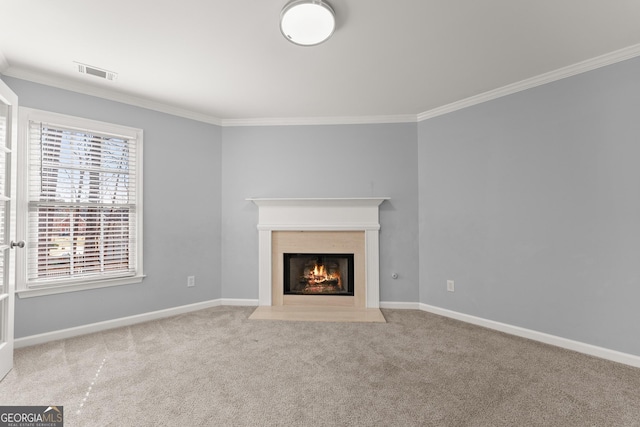 unfurnished living room featuring ornamental molding, carpet flooring, visible vents, and baseboards