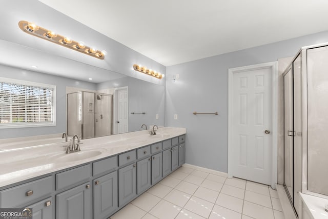 bathroom featuring double vanity, tile patterned flooring, a sink, and a shower stall