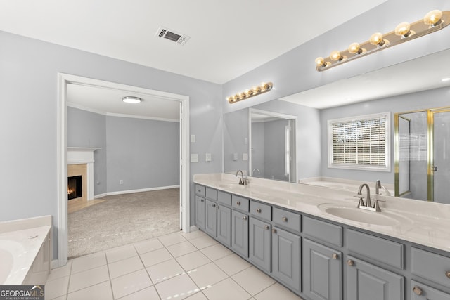 full bath with double vanity, a fireplace, a sink, and visible vents