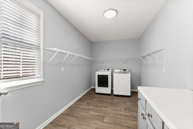 washroom with independent washer and dryer, wood finished floors, cabinet space, and baseboards