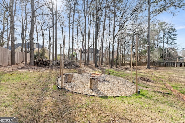 view of yard with an outdoor fire pit and fence