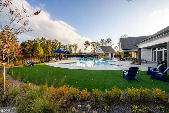 view of swimming pool featuring a yard and a patio