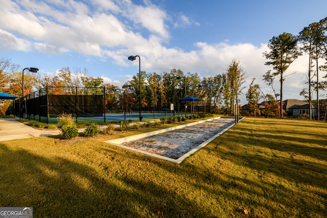 view of community with a lawn and tennis court