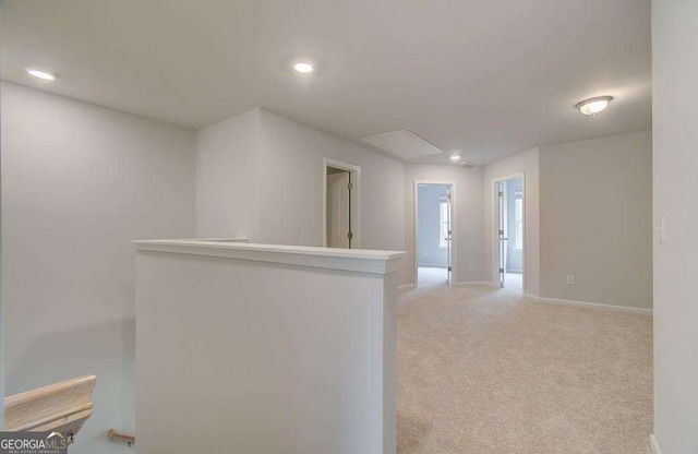 corridor featuring light carpet, attic access, recessed lighting, and an upstairs landing