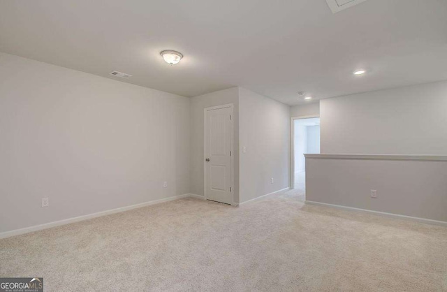 empty room with visible vents, light carpet, and baseboards