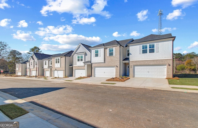 multi unit property with a garage, a residential view, concrete driveway, and brick siding