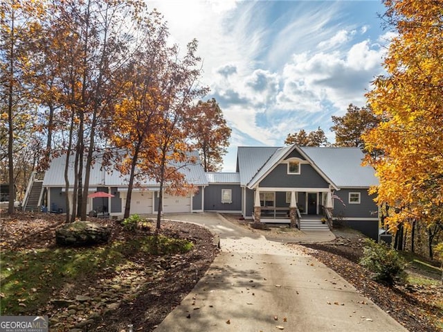 view of front of property featuring driveway, a garage, and metal roof