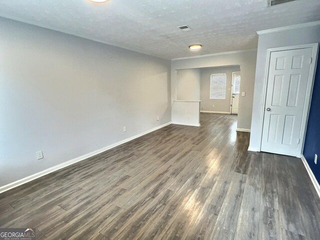 unfurnished living room featuring wood-type flooring and ornamental molding