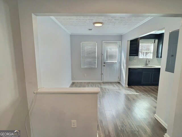 kitchen featuring sink, electric panel, tasteful backsplash, black appliances, and light wood-type flooring