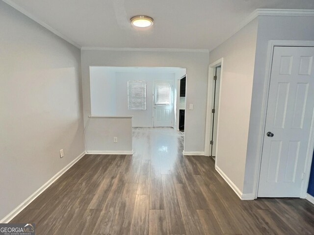 unfurnished bedroom with crown molding and dark hardwood / wood-style flooring