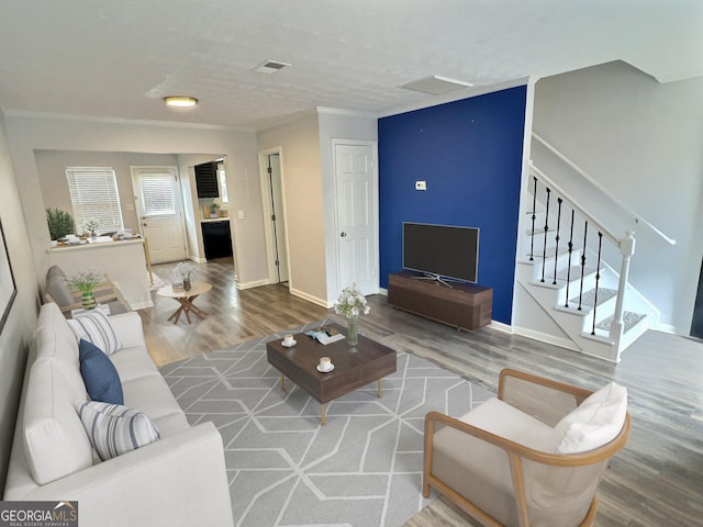 living room featuring hardwood / wood-style flooring and crown molding