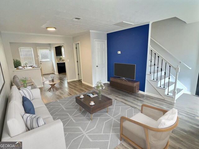 living room with hardwood / wood-style flooring and ornamental molding