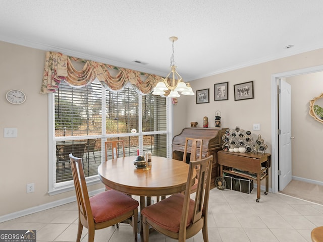 tiled dining room featuring a textured ceiling, ornamental molding, and a chandelier